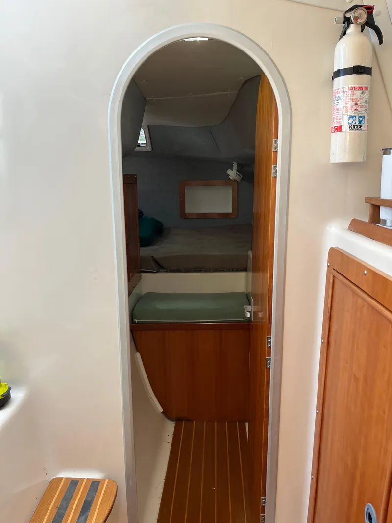 Slide: The Image of Interior of a 2003 PDQ 32 boat, featuring a cozy cabin and wooden accents. - 48