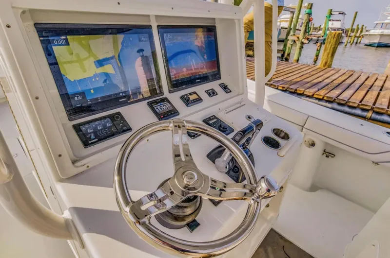 Slide: The Image of 2017 Yellowfin 36 Offshore boat dashboard with dual screens and steering wheel. - 10
