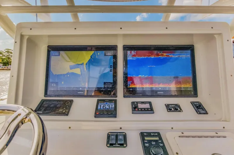 Slide: The Image of 2017 Yellowfin 36 Offshore boat dashboard with dual navigation screens and controls. - 11
