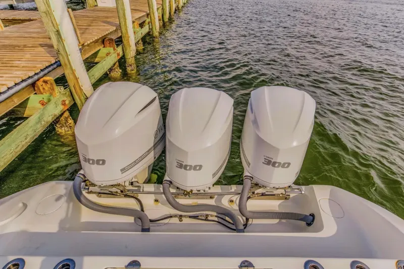 Slide: The Image of Triple 300 horsepower engines on a 2017 Yellowfin 36 Offshore boat docked by wooden pier. - 14