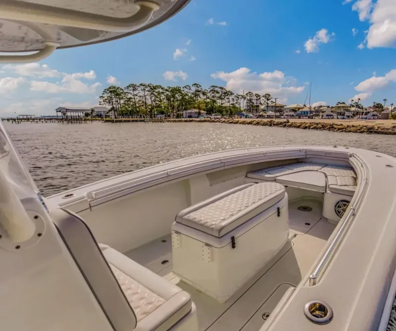 Slide: The Image of 2017 Yellowfin 36 Offshore boat with spacious seating, docked near a scenic shoreline. - 15