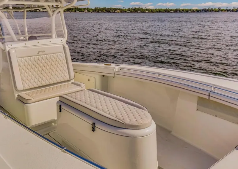 Slide: The Image of 2017 Yellowfin 36 Offshore boat interior with cushioned seating, overlooking calm waters. - 19