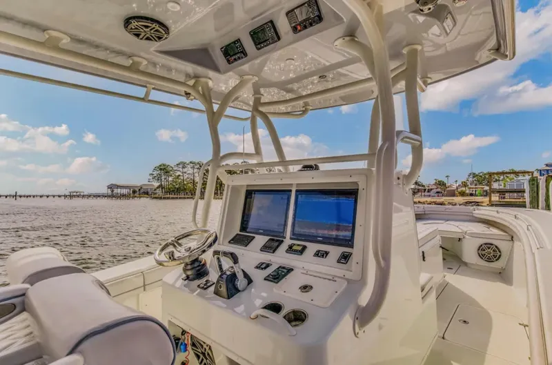 Slide: The Image of 2017 Yellowfin 36 Offshore boat cockpit with navigation screens and steering wheel, dockside view. - 9