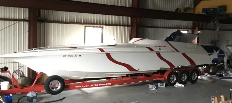 Slide: The Image of 1998 Fountain 42 Lightning speedboat on trailer in warehouse, red and white design. - 15