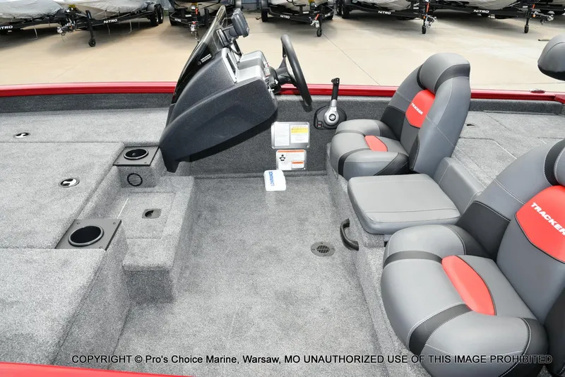Slide: The Image of 2025 Tracker Pro Team 190 TX boat interior with gray and red seating, console, and storage compartments. - 13