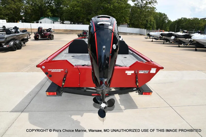 Slide: The Image of 2025 Tracker Pro Team 190 TX boat with outboard motor, parked on concrete lot. - 21