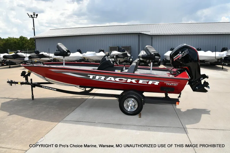 Slide: The Image of 2025 Tracker Pro Team 190 TX boat, red, on trailer, parked outdoors. - 23