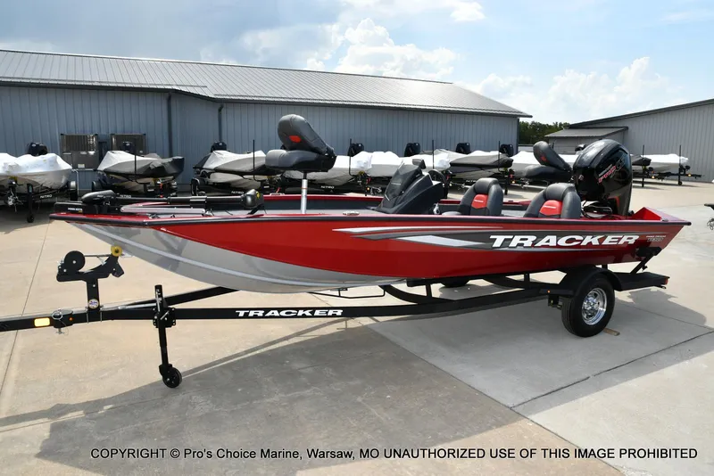 Slide: The Image of 2025 Tracker Pro Team 190 TX boat in red on trailer, parked outdoors. - 24