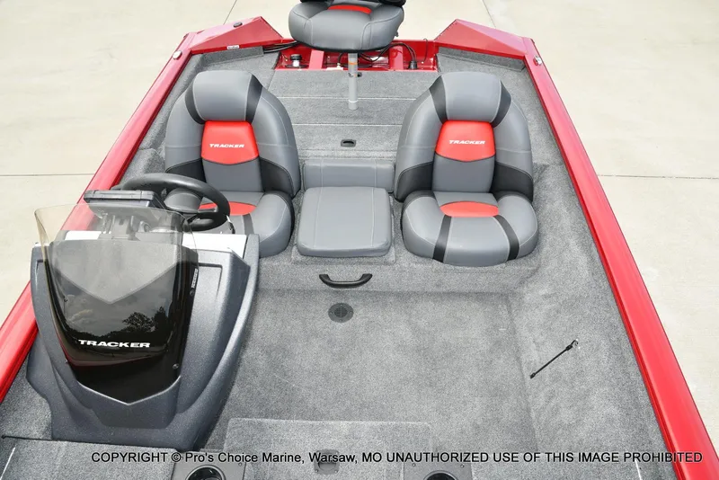 Slide: The Image of 2025 Tracker Pro Team 190 TX boat interior with red and gray seating, steering console, and carpeted floor. - 41