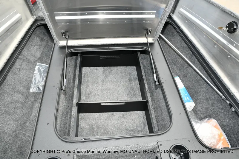 Slide: The Image of Open storage compartment of 2025 Tracker Pro Team 190 TX boat, featuring carpeted interior. - 48