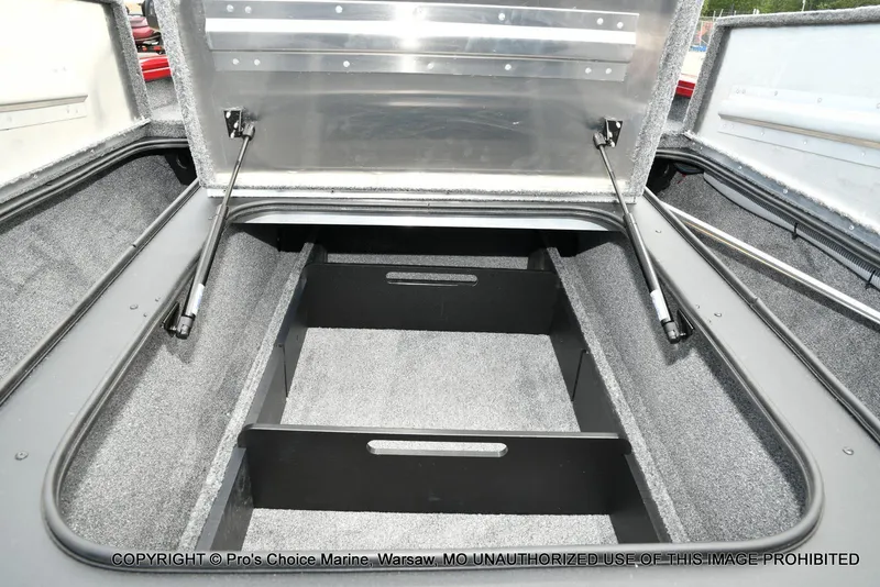 Slide: The Image of Open storage compartment of 2025 Tracker Pro Team 190 TX boat, featuring carpeted interior. - 49