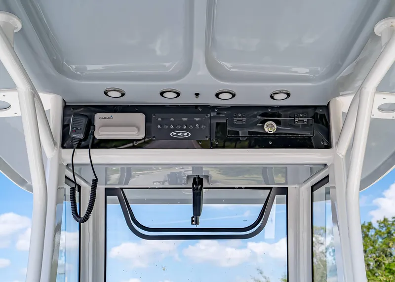 Slide: The Image of 2025 Sea Hunt Gamefish 25 console with Garmin electronics and overhead storage. - 11