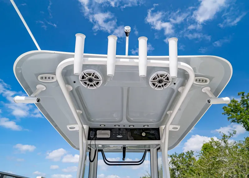 Slide: The Image of 2025 Sea Hunt Gamefish 25 boat top view with rod holders and speakers against blue sky. - 17