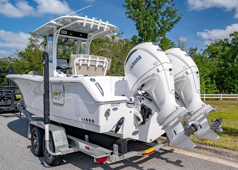 Slide: The Image of 2025 Sea Hunt Gamefish 25 boat with dual Yamaha engines on a trailer. - 4