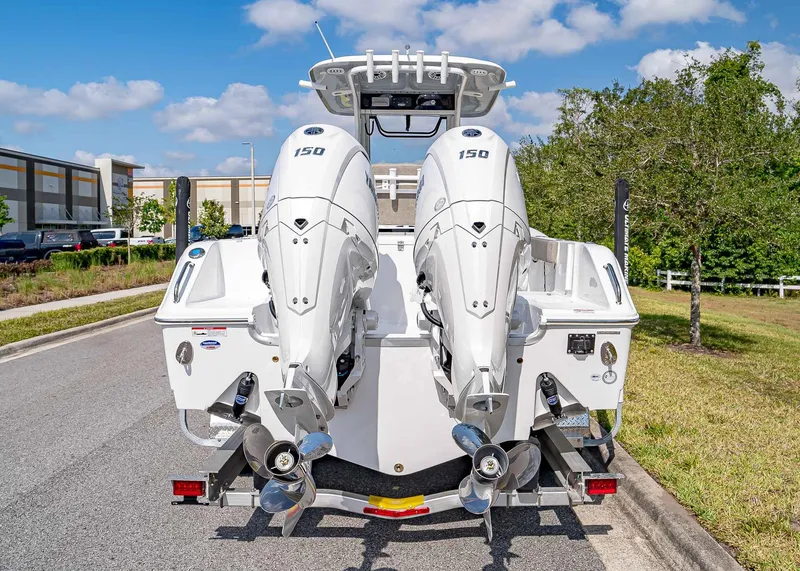 Slide: The Image of 2025 Sea Hunt Gamefish 25 boat with dual 150 horsepower engines, parked on a sunny day. - 5