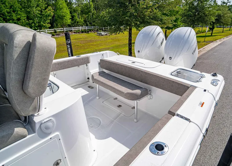 Slide: The Image of 2025 Sea Hunt Gamefish 25 boat interior with seating and dual engines, parked on a sunny day. - 9