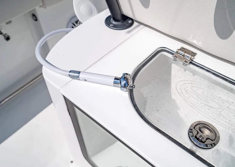 Slide: The Image of 2025 Sea Hunt Gamefish 25 boat detail with hose and storage compartment. - 11