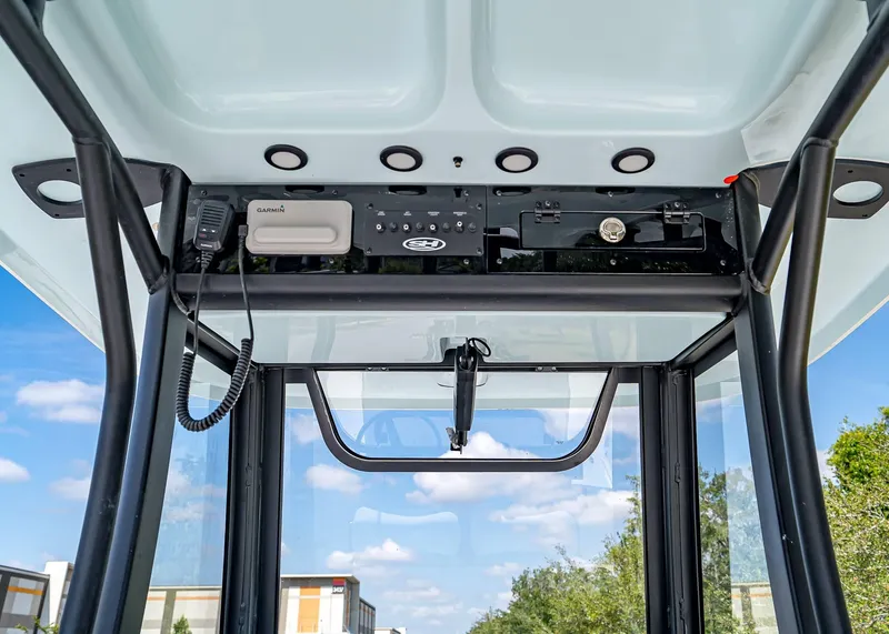 Slide: The Image of 2025 Sea Hunt Gamefish 25 boat console with Garmin equipment and clear sky background. - 22