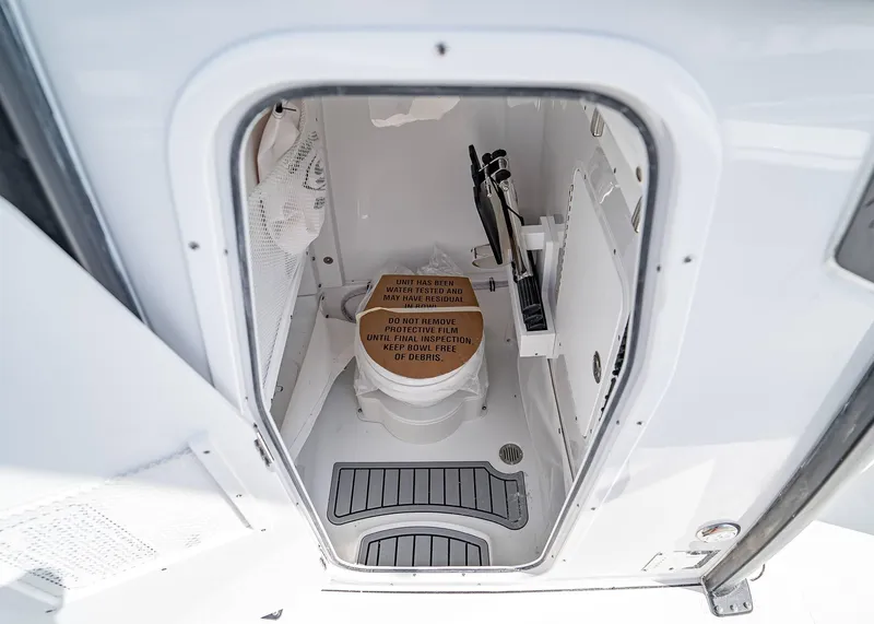Slide: The Image of Interior of 2025 Sea Hunt Gamefish 25 boat, featuring a compact marine toilet. - 24