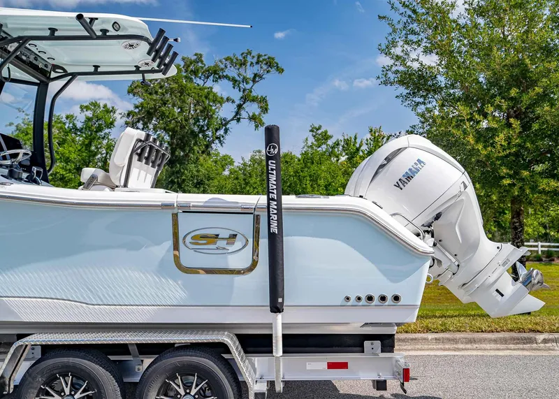 Slide: The Image of 2025 Sea Hunt Gamefish 25 boat with Yamaha engine on trailer, outdoors. - 3