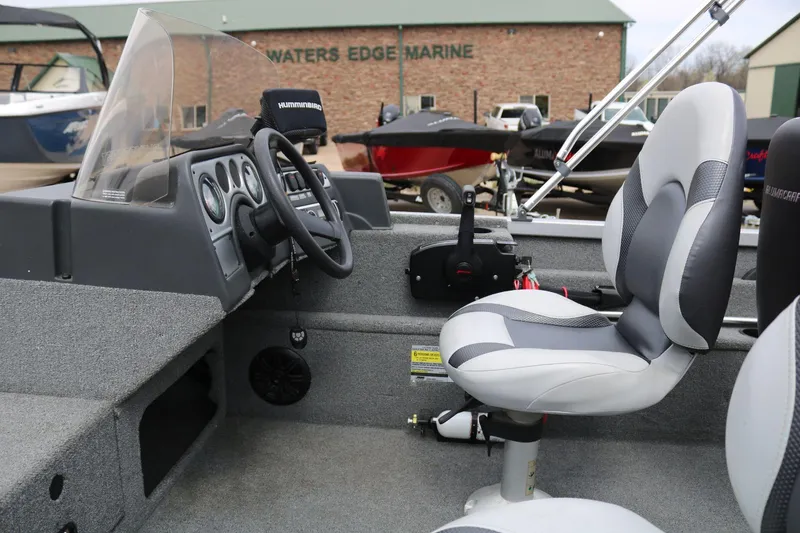 Slide: The Image of 2014 Alumacraft Competitor 165 CS boat interior with steering wheel and cushioned seat. - 15