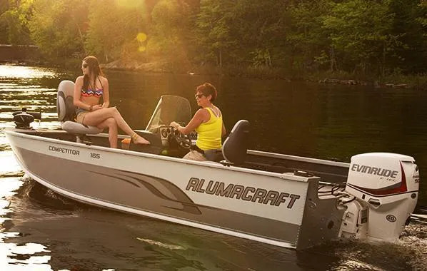 Slide: The Image of 2014 Alumacraft Competitor 165 CS boat on a serene lake with two people enjoying the ride. - 31