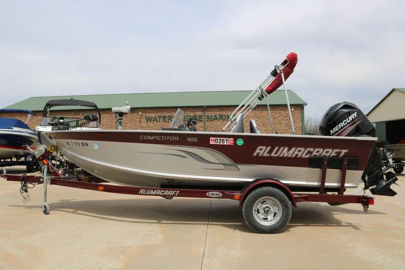 Slide: The Image of 2014 Alumacraft Competitor 165 CS boat on trailer, parked outside a marine shop. - 5