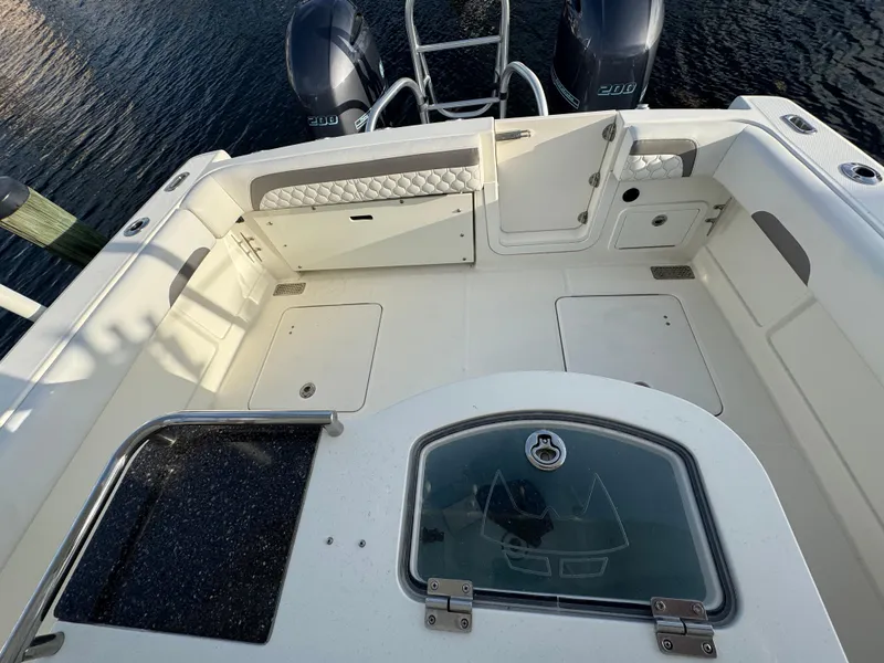 Slide: The Image of 2018 World Cat 280 CC-X boat deck with dual engines and storage compartments. - 13