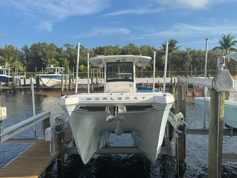 Slide: The Image of 2018 World Cat 280 CC-X catamaran docked at marina with lush greenery. - 5