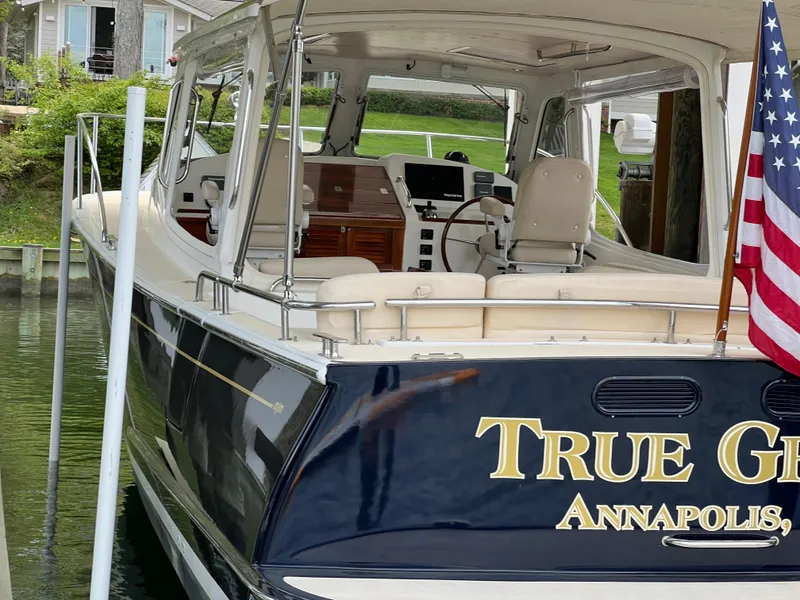 Slide: The Image of 2011 MJM 36Z boat docked, featuring "True Grit" name and American flag. - 20