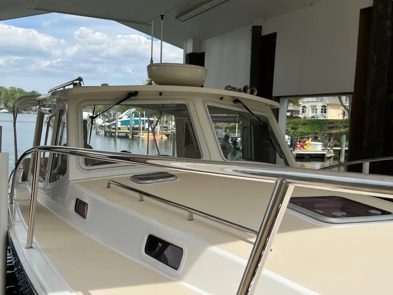 Slide: The Image of 2011 MJM 36Z boat docked under a covered marina with scenic waterfront views. - 23