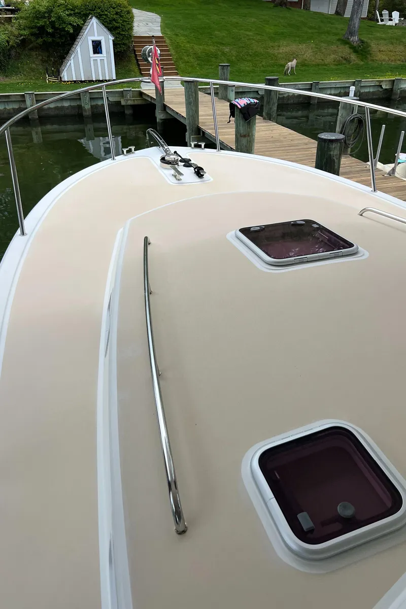 Slide: The Image of 2011 MJM 36Z boat deck with hatches, docked near a grassy shoreline. - 27