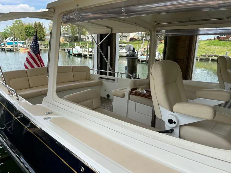 Slide: The Image of 2011 MJM 36Z boat interior with beige seating, docked by a marina. - 28
