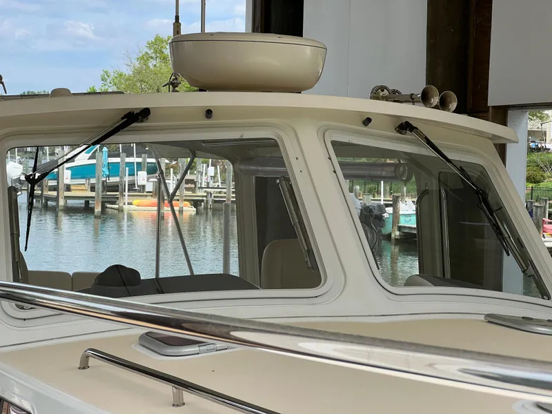 Slide: The Image of 2011 MJM 36Z boat docked, showcasing windshield and marina background. - 29