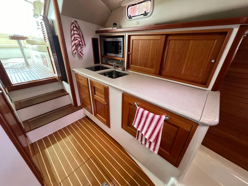 Slide: The Image of 2011 MJM 36Z yacht interior with wooden cabinetry and modern kitchen amenities. - 39