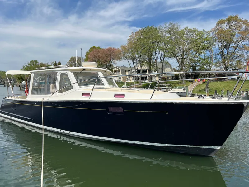 Slide: The Image of 2011 MJM 36Z boat docked on a calm lake with trees in the background. - 8