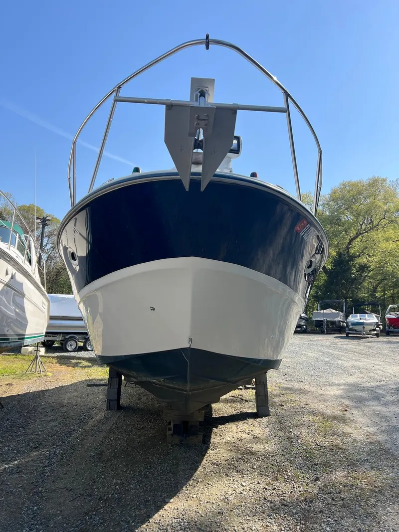 Slide: The Image of 2006 Bayliner 305 boat on dry land, front view, sunny day. - 10