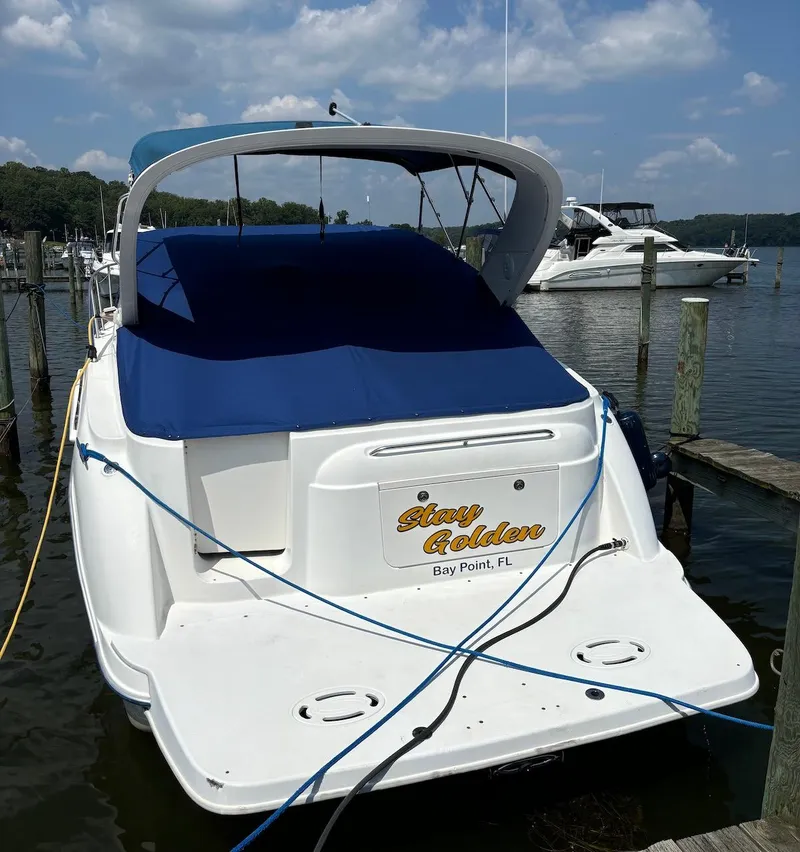 Slide: The Image of 2006 Bayliner 305 boat docked at marina under blue sky. - 11