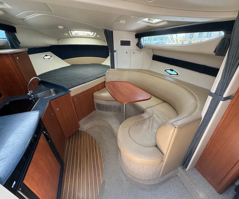 Slide: The Image of Interior of a 2006 Bayliner 305 boat with kitchenette and seating area. - 12