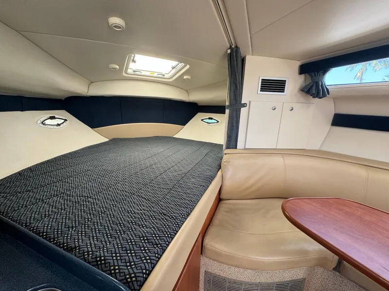 Slide: The Image of Interior of 2006 Bayliner 305 boat with bed, seating, and table. - 14