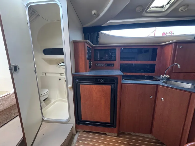 Slide: The Image of Interior of 2006 Bayliner 305 boat with kitchenette and bathroom. - 15