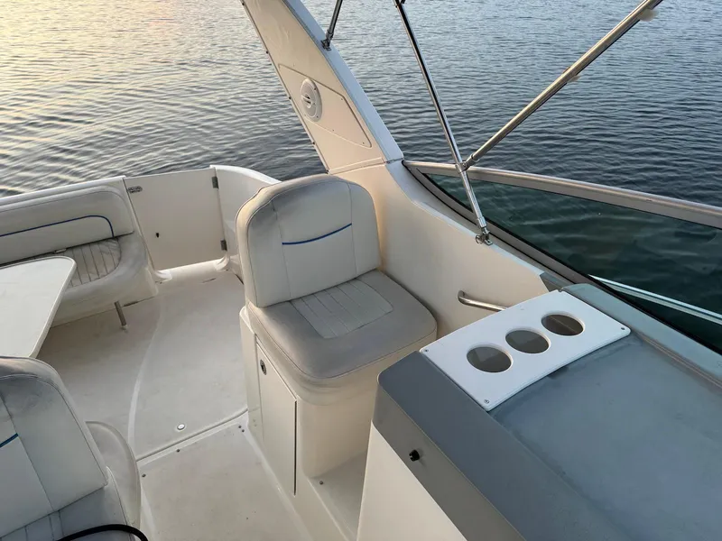 Slide: The Image of 2006 Bayliner 305 boat interior with seating and cup holders, overlooking calm water. - 4