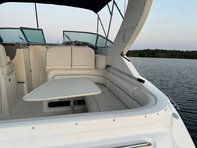 Slide: The Image of 2006 Bayliner 305 boat interior with seating and table on calm water. - 5