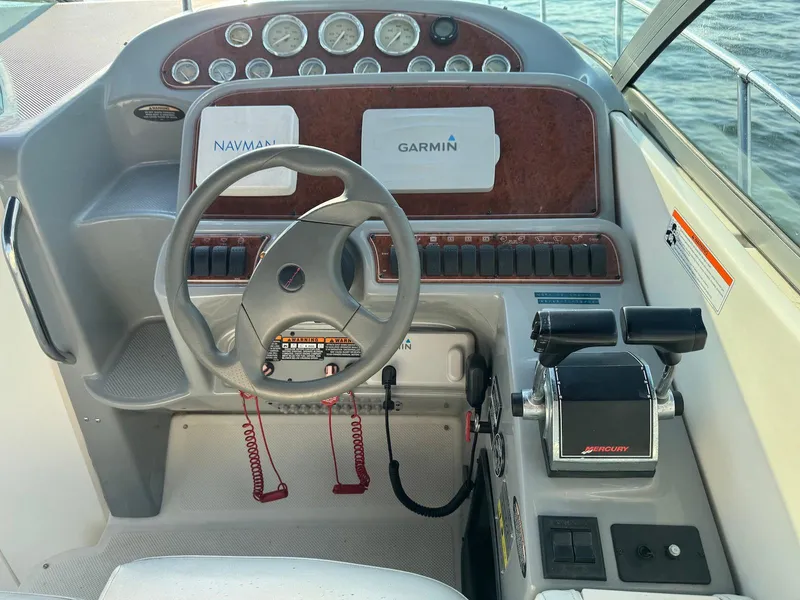 Slide: The Image of 2006 Bayliner 305 boat dashboard with steering wheel and navigation controls. - 6