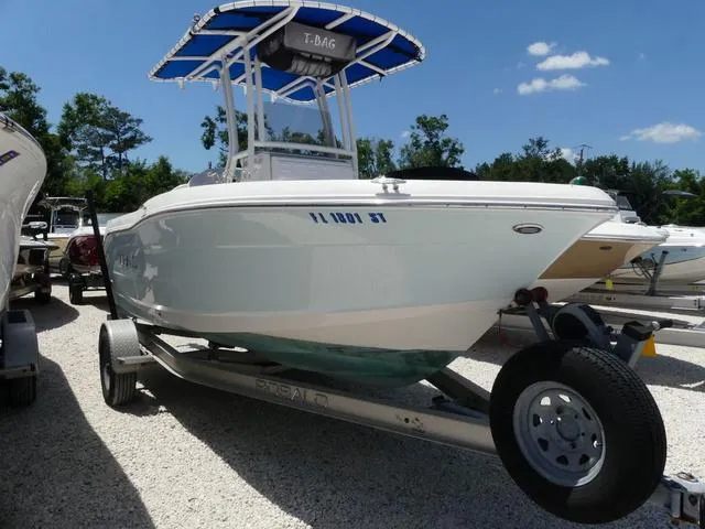 Slide: The Image of 2018 Robalo R180 boat cruising on a serene lake under a clear blue sky. - 1