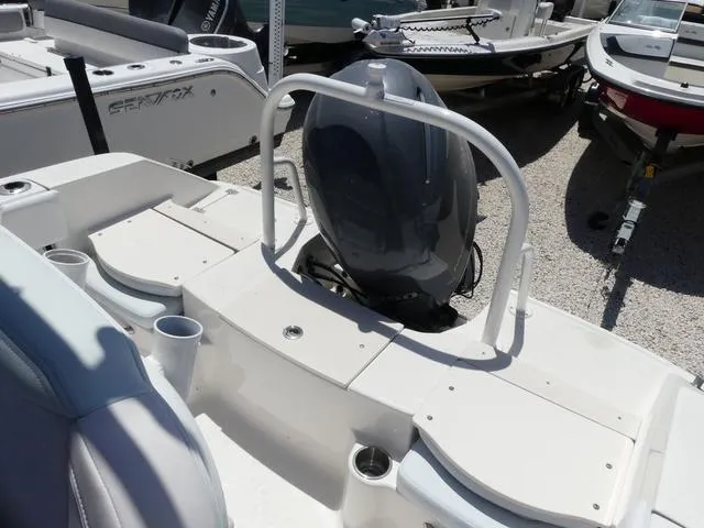 Slide: The Image of 2018 Robalo R180 boat with outboard motor, white seating, and cup holders. - 9