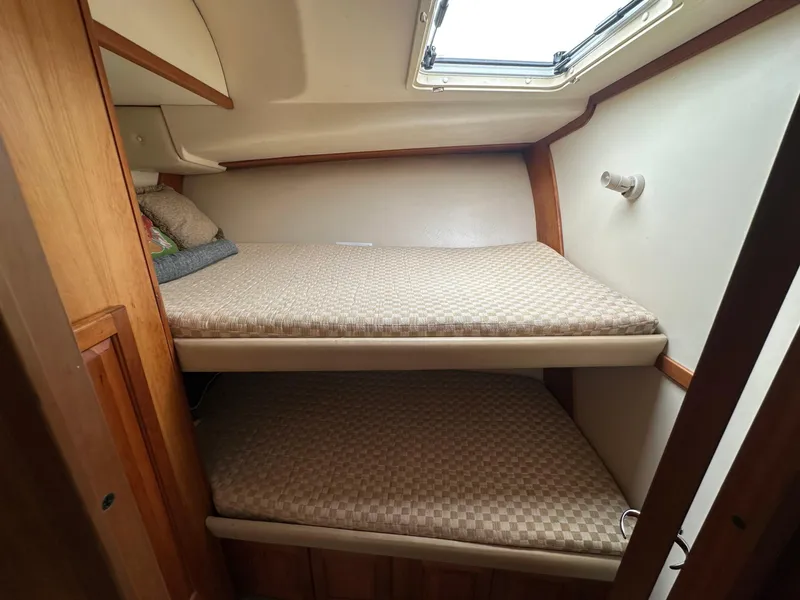 Slide: The Image of 2003 Luhrs 40 Convertible cabin with bunk beds and natural light. - 12