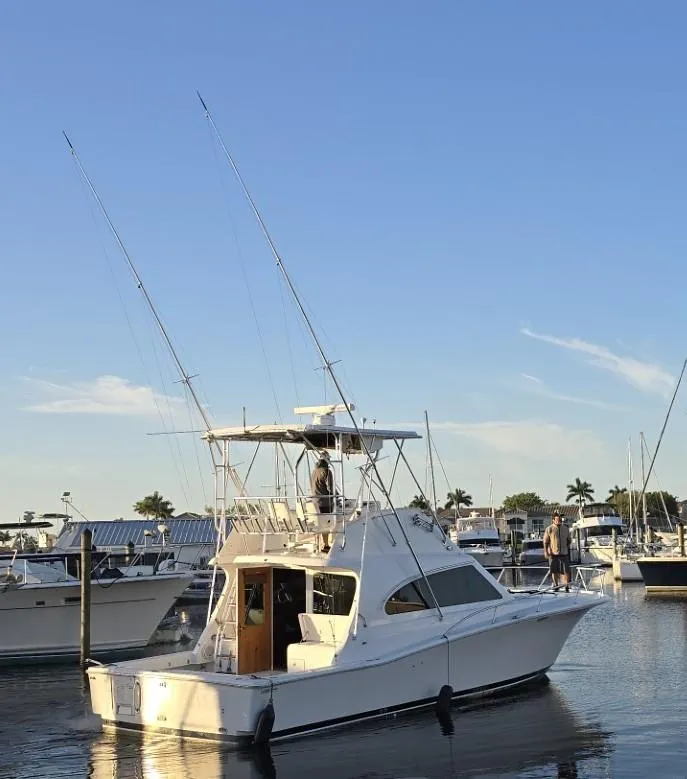 Slide: The Image of 2003 Luhrs 40 Convertible yacht docked at marina under clear blue sky. - 18