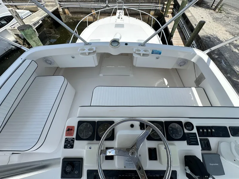 Slide: The Image of 2003 Luhrs 40 Convertible boat cockpit with steering wheel and seating area. - 2