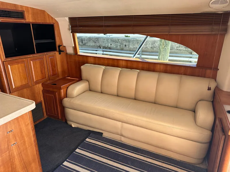 Slide: The Image of 2003 Luhrs 40 Convertible yacht interior with beige sofa and wooden cabinetry. - 29